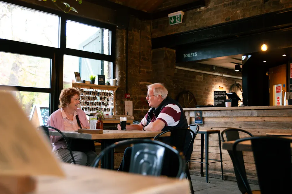 Pareja de adultos mayores conversando en la mesa de un café
